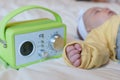 A baby with onesie sleeps in the bed