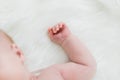 Baby Sleeping with Hands Curled Against White Blanket