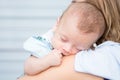 Baby sleeping on his mother`s shoulder Royalty Free Stock Photo