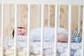 The baby sleeps in the crib. A charming baby sleeps in a crib for sleeping attached to the bed of the parents. A small child Royalty Free Stock Photo