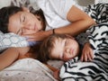 The baby sleeps with mom in bed. Cute boy and his mother lying on the sofa in the bedroom, sleep peacefully during the day. Safe Royalty Free Stock Photo