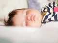 Baby sleeps in parents bed. arms outstretched baby`s restful sleep. close-up. child 0-1 years old. adorable lovely baby sleeps