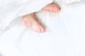 Baby sleeps on a white bed with his feet. Selective focus. Royalty Free Stock Photo