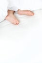 Baby sleeps on a white bed with his feet. Selective focus. Royalty Free Stock Photo