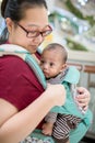 Baby in sling indoor. Little baby boy and her mother walking in department store. Royalty Free Stock Photo