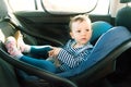 Baby smile in a safety car seat. security. one year old child girl in blue wear sit on auto cradle. Rules for the Safe Transport o Royalty Free Stock Photo