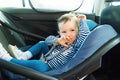 Baby smile in a safety car seat. security. one year old child girl in blue wear sit on auto cradle. Rules for the Safe Transport o Royalty Free Stock Photo