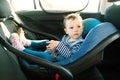 Baby smile in a safety car seat. security. one year old child girl in blue wear sit on auto cradle. Rules for the Safe Transport o Royalty Free Stock Photo