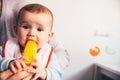 Baby smiling and drooling when trying for the first time an ice cream from his mother`s hands, infant feeding through the baby le Royalty Free Stock Photo