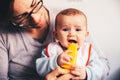 Baby smiling and drooling when trying for the first time an ice cream from his mother`s hands, infant feeding through the baby le Royalty Free Stock Photo