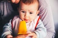 Baby smiling and drooling when trying for the first time an ice cream from his mother`s hands, infant feeding through the baby le Royalty Free Stock Photo