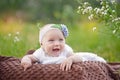 Baby smiling and looking up to camera outdoors in sunlight