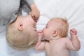 Baby and smiling older brother are lying on the bed. Funny and interact. Top view Royalty Free Stock Photo