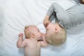 Baby and smiling older brother are lying on the bed. Funny and interact. Top view Royalty Free Stock Photo