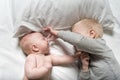 Baby and smiling older brother are lying on the bed. They play, funny and interact. Top view Royalty Free Stock Photo