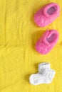 Baby socks and booties on yellow background Royalty Free Stock Photo