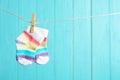 Baby socks on laundry line against color wooden background. Child accessories Royalty Free Stock Photo