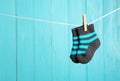 Baby socks on laundry line against color wooden background, space for text. Royalty Free Stock Photo