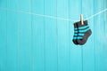 Baby socks on laundry line against color wooden background, space for text. Royalty Free Stock Photo