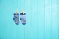 Baby socks on laundry line against color wooden background. Child accessories Royalty Free Stock Photo