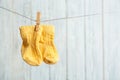 Baby socks on laundry line against wooden background, space for text. Royalty Free Stock Photo