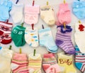 Baby socks and mittens hanging on lines with miniature clothes pegs Royalty Free Stock Photo