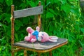 Baby soft toys pink Rabbit lying on an old chair in the summer