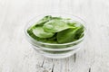 Baby spinach leaves in bowl on white rustic table, organic and healthy food Royalty Free Stock Photo