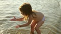 Baby splashing in the water. splashing water. Cute child happily plays on the beach. happy child bathes in the sunset on