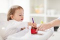 Baby with spoon eating puree from jar at home Royalty Free Stock Photo
