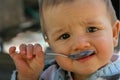 Baby with spoon in his mouth Royalty Free Stock Photo