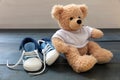 Baby shoes and teddy bear on blue wooden floor background Royalty Free Stock Photo