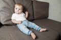 Baby sprawled on couch with a baby`s dummy in his mouth Royalty Free Stock Photo