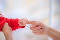 Close up Infant in gently holding mom finger. Baby squeezes parent hand on white background. Family and Mothers day concept. Royalty Free Stock Photo