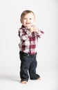 Baby Stands in Flannel and Jeans Holding Hands