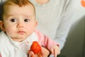 Baby starting by tasting a strawberry using the Baby led weaning BLW method Royalty Free Stock Photo