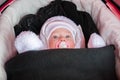 Baby in stroller is dressed and warmly wrapped in freezing winter Royalty Free Stock Photo