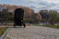 Baby stroller for a small child in the background of a natural forest park, paths of stones Royalty Free Stock Photo