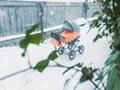 Baby stroller on the street. View through the window from the house with flowers on the windowsill. Royalty Free Stock Photo