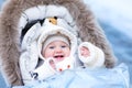 Baby in stroller in a winter park Royalty Free Stock Photo
