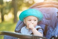 Baby sucking thumb in carriage in the park Royalty Free Stock Photo