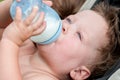 Baby sucks a bottle with milk