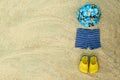 Baby summer beachwear, flip flops, hat, shorts on sand beach