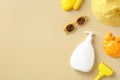 Baby sun protection concept. Flat lay sunscreen cream bottle, sun glasses, panama hat, sand molds on beige table. Top view Royalty Free Stock Photo