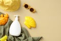 Baby sun safety concept. Sunscreen cream bottle, sun glasses, sand molds, towel, panama hat on beige table. Flat lay, top view