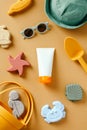 Baby sunscreen lotion tube with beach toys on color background. Flat lay, top view Royalty Free Stock Photo