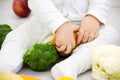 Baby surrounded with fruits and vegetables on yellow blanket, healthy child nutrition first food of the child Royalty Free Stock Photo