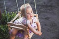 Baby swinging in the yard on a children`s swing sticking