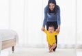 Baby taking first steps learning to walk with mother