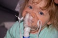 Baby taking respiratory therapy. Mom`s hand holding the mask of a nebuliser Royalty Free Stock Photo
